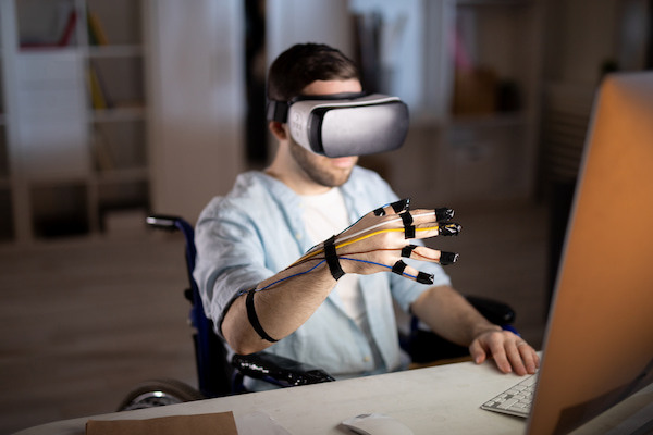 Uomo su sedia a rotelle entra nel metaverso grazie a un visore di realtà virtuale.
