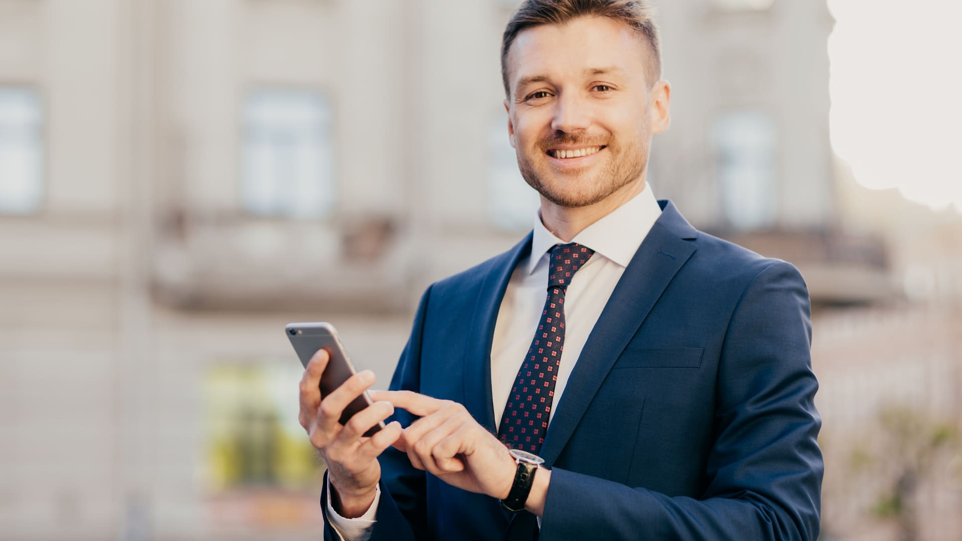 Uomo d'affari con smartphone esegue pagamento cardless grazie al PIS.