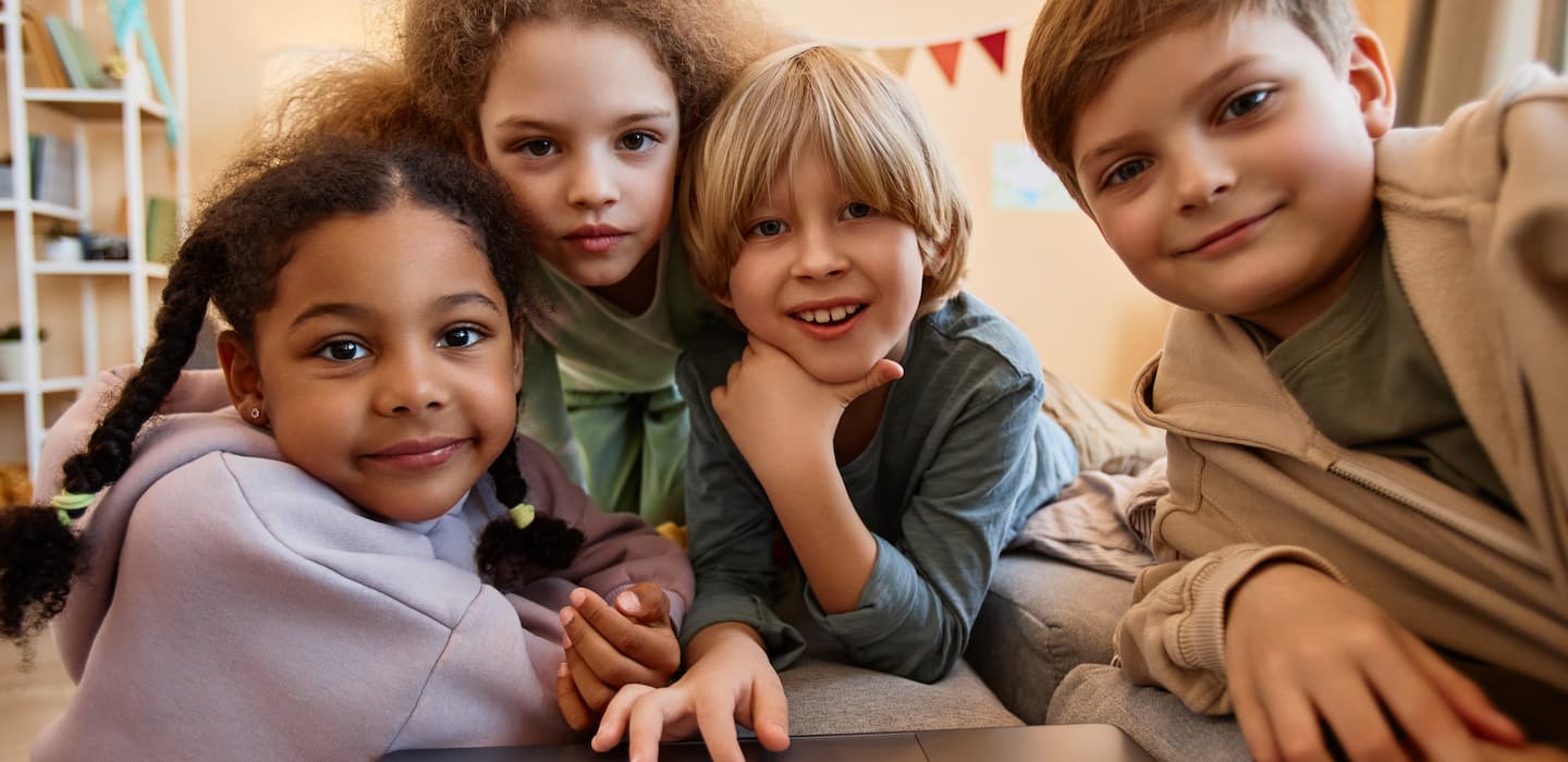 Gruppo di bambini che guardano lo schermo di un portatile.